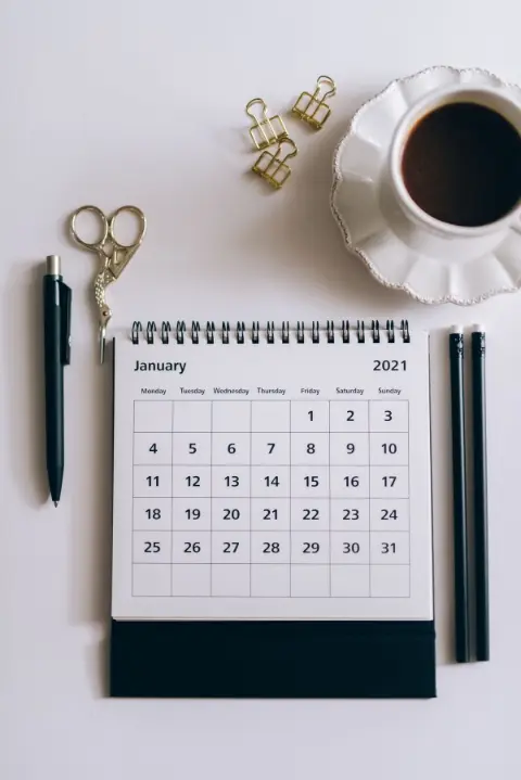 A desk calendar beside a black click pen